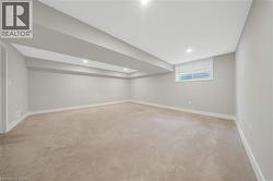 Spacious finished room with neutral carpet flooring, light gray walls, and recessed lighting - 