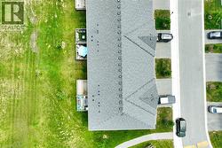 Aerial perspective highlighting a multi-unit residential property with a gray shingle roof - 