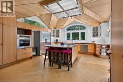Kitchen featuring a central skylight, wood plank ceiling, and arched window - 