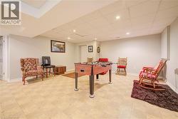 Finished basement featuring light-toned square tile flooring, recessed lighting, and painted walls - 