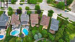 Aerial perspective showcasing a residential neighborhood with properties featuring varied rooflines, private swimming pools, and extensive green space - 