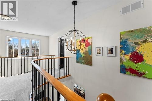 Curved staircase with black metal spindles and a wood-finish handrail - 26 Shadyridge Place, Kitchener, ON 