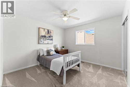 Bright room featuring a ceiling fan with integrated lighting, a window with white trim, and light-toned wall-to-wall carpeting - 26 Shadyridge Place, Kitchener, ON 