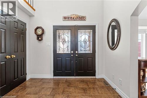 Foyer featuring dual entry doors with decorative glass inserts, ceramic tile flooring, and a paneled closet door - 26 Shadyridge Place, Kitchener, ON 