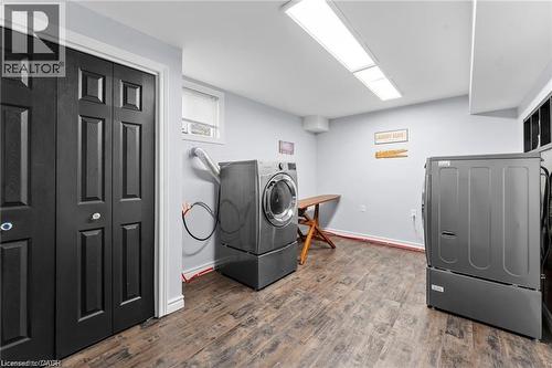 Spacious utility room featuring wood-finish flooring, light gray walls, and bright overhead lighting - 26 Shadyridge Place, Kitchener, ON 