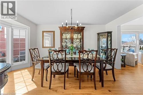Bright dining area featuring light wood-finish flooring, a bay window with white trim, and a built-in display cabinet - 26 Shadyridge Place, Kitchener, ON 