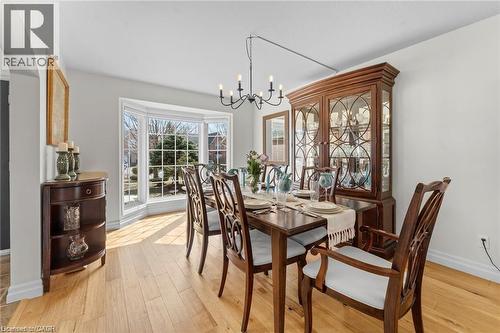 Spacious dining area featuring light wood-finish flooring, a prominent bay window, and a chandelier-style light fixture - 26 Shadyridge Place, Kitchener, ON 