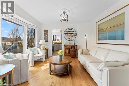 Living area featuring wood-finish flooring, a bay window, a recessed ceiling, and a prominent archway - 26 Shadyridge Place, Kitchener, ON 
