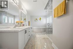 Spacious bathroom featuring a dual vanity with a light-colored countertop and white cabinetry - 