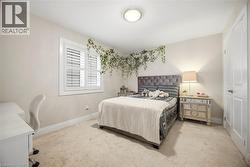 Neutral-toned bedroom featuring carpet flooring and white trim - 