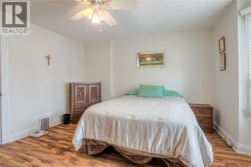 Bedroom featuring wood-finish flooring, white walls, and a ceiling fan with integrated lighting - 41 Springhurst Avenue, Toronto, ON 