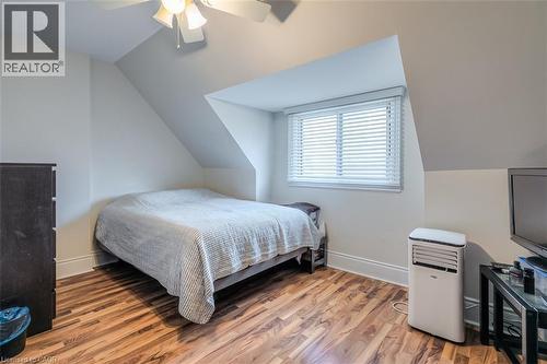 Attic room featuring sloped ceilings, wood-finish flooring, and a window with horizontal blinds - 41 Springhurst Avenue, Toronto, ON 