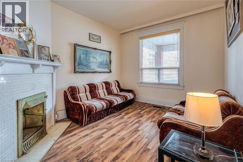 Room featuring wood-finish flooring and a white-painted fireplace with tile surround - 41 Springhurst Avenue, Toronto, ON 
