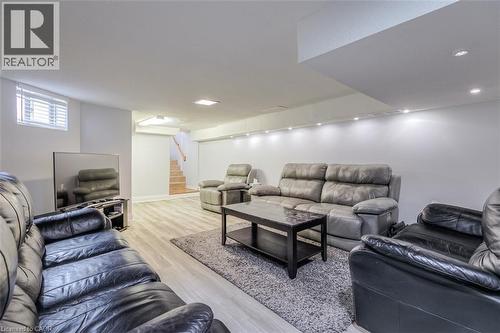 Spacious recreation room featuring recessed lighting, light wood-finish flooring, a white trim baseboard, and a stairway with wood treads - 41 Springhurst Avenue, Toronto, ON 