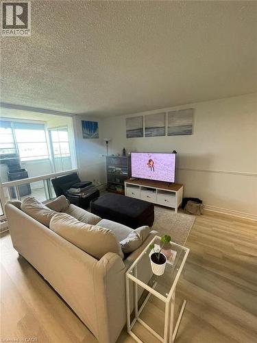 Open-concept living space featuring light wood-finish flooring and a neutral color palette - 225 Harvard Place Unit# 1505, Waterloo, ON 