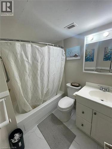 Bathroom featuring a white bathtub with shower, white toilet, and a white vanity with an integrated sink - 225 Harvard Place Unit# 1505, Waterloo, ON 