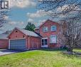 Brick exterior featuring a two-car garage, bay window, and gabled roofline - 27 Tassie Lane, Cambridge, ON 