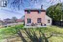 Brick exterior with a large patio area, double-door access, upper-level windows, a prominent chimney, and a fenced perimeter - 27 Tassie Lane, Cambridge, ON 