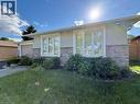 Front exterior featuring a stucco finish, stone veneer siding, white trim windows, and a paved driveway - 3135 Palmer Drive, Burlington, ON 