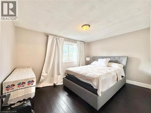 Room featuring wood-finish flooring, neutral wall tones, and a window with white drapery - 3135 Palmer Drive, Burlington, ON 
