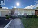 Exterior featuring a light stucco finish, stone veneer accents, multiple large windows, an attached garage, and a paver walkway - 3135 Palmer Drive, Burlington, ON 