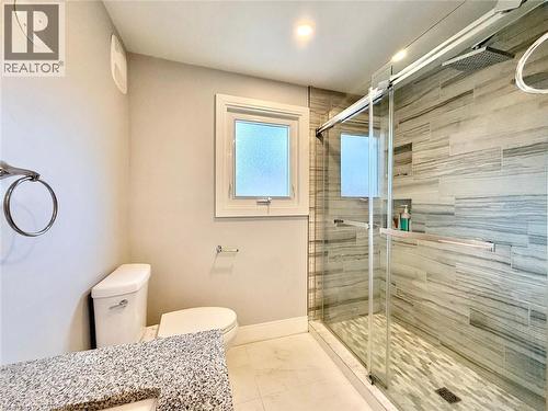 Three-quarter bathroom featuring a granite-finish vanity, white toilet, and a glass-enclosed shower - 3135 Palmer Drive, Burlington, ON 
