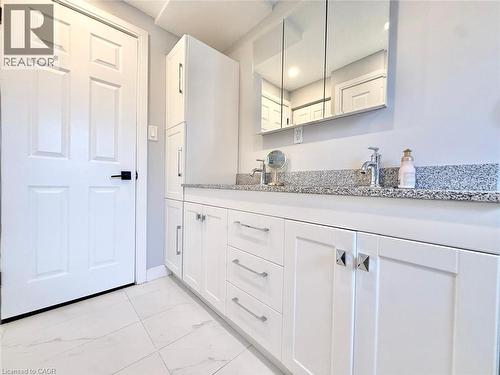 White shaker-style vanity with dual chrome faucets and granite countertop - 3135 Palmer Drive, Burlington, ON 