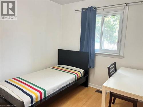 Bright room with wood-finish flooring, a white window frame, and a window allowing natural light - 110 Peppler Street, Waterloo, ON 