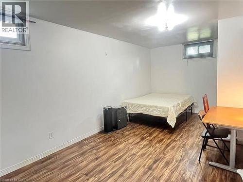 Room featuring wood-finish flooring, white painted walls, and a ceiling-mounted light fixture - 110 Peppler Street, Waterloo, ON 