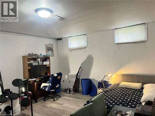 Interior space with wood-finish flooring, two upper windows, and a flush-mount ceiling light fixture - 110 Peppler Street, Waterloo, ON 