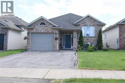 Brick and siding exterior featuring a prominent front-facing garage with a light gray door - 