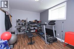 Room featuring wood-finish flooring, a white-framed window, and light grey walls - 
