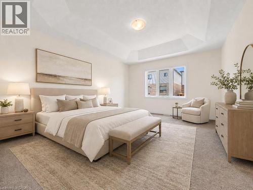 Spacious bedroom featuring a tray ceiling, carpeted flooring, and a large window - 76 Grassbourne Avenue, Kitchener, ON 