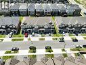 Contemporary townhome architecture featuring brick and siding exteriors, individual driveways, and manicured front lawns - 76 Grassbourne Avenue, Kitchener, ON 