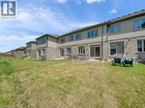 Rear exterior featuring brick and siding facade, multiple windows, and sliding glass doors providing outdoor access - 76 Grassbourne Avenue, Kitchener, ON 