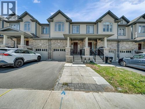 Contemporary townhome exterior featuring light-toned siding and stone veneer accents - 76 Grassbourne Avenue, Kitchener, ON 
