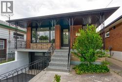 Brick exterior featuring a covered front porch with decorative ironwork, multi-pane front door, and a prominent front window - 
