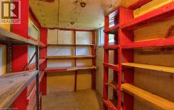 Utility room featuring built-in shelving, a concrete floor, and a small window - 