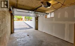 Single-car garage with concrete block wall, unfinished drywall, and concrete flooring - 