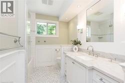 Bathroom featuring a dual vanity with a marble countertop, undermount sink, and polished chrome faucet - 