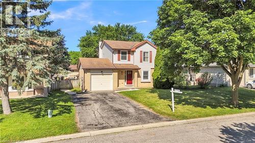Two-story residence featuring light-colored siding, a prominent red front door, and a single-car garage - 127 Acorn Crescent, London, ON 