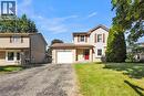 Two-story property featuring a red front door, attached single-car garage, and a lush green lawn - 127 Acorn Crescent, London, ON 
