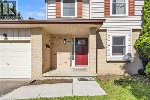 Brick and siding exterior featuring a covered entryway with a red front door - 127 Acorn Crescent, London, ON 