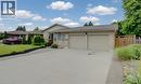 Stone and siding exterior with a two-car garage, concrete driveway, and established front landscaping - 127 Strathcona Crescent, Kitchener, ON 