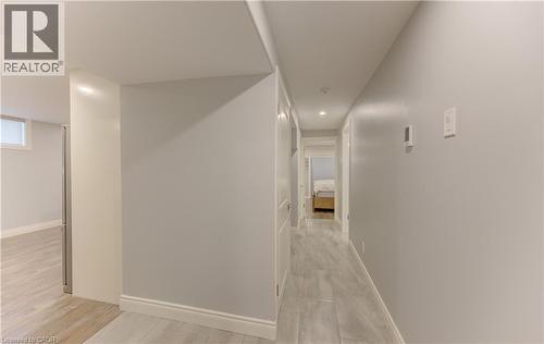 Hallway featuring light wood-finish flooring, light grey walls, white trim, and recessed lighting - 127 Strathcona Crescent, Kitchener, ON 