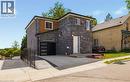 Contemporary exterior with mixed material facade, featuring dark stone cladding, wood-finish siding, and brickwork - 129 St George Street, Kitchener, ON 