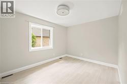 Bright room featuring light-toned walls and wood-finish flooring - 