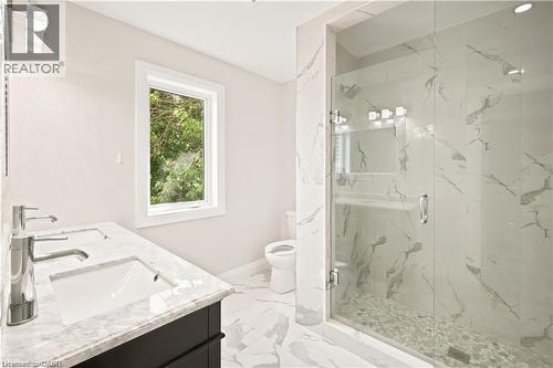 Contemporary bathroom featuring a spacious glass-enclosed shower with pebble flooring and large-format wall tiles - 129 St George Street, Kitchener, ON 