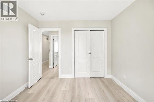 Light wood-finish flooring, white baseboards, and neutral wall tones - 129 St George Street, Kitchener, ON 