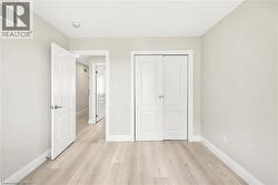 Light wood-finish flooring, white baseboards, and neutral wall tones - 